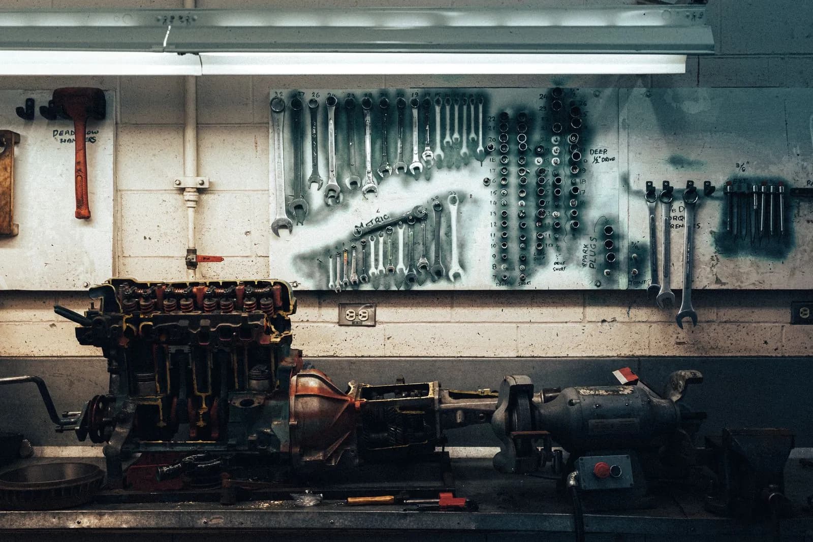 Wall of wrenches and an engine block on a shop bench