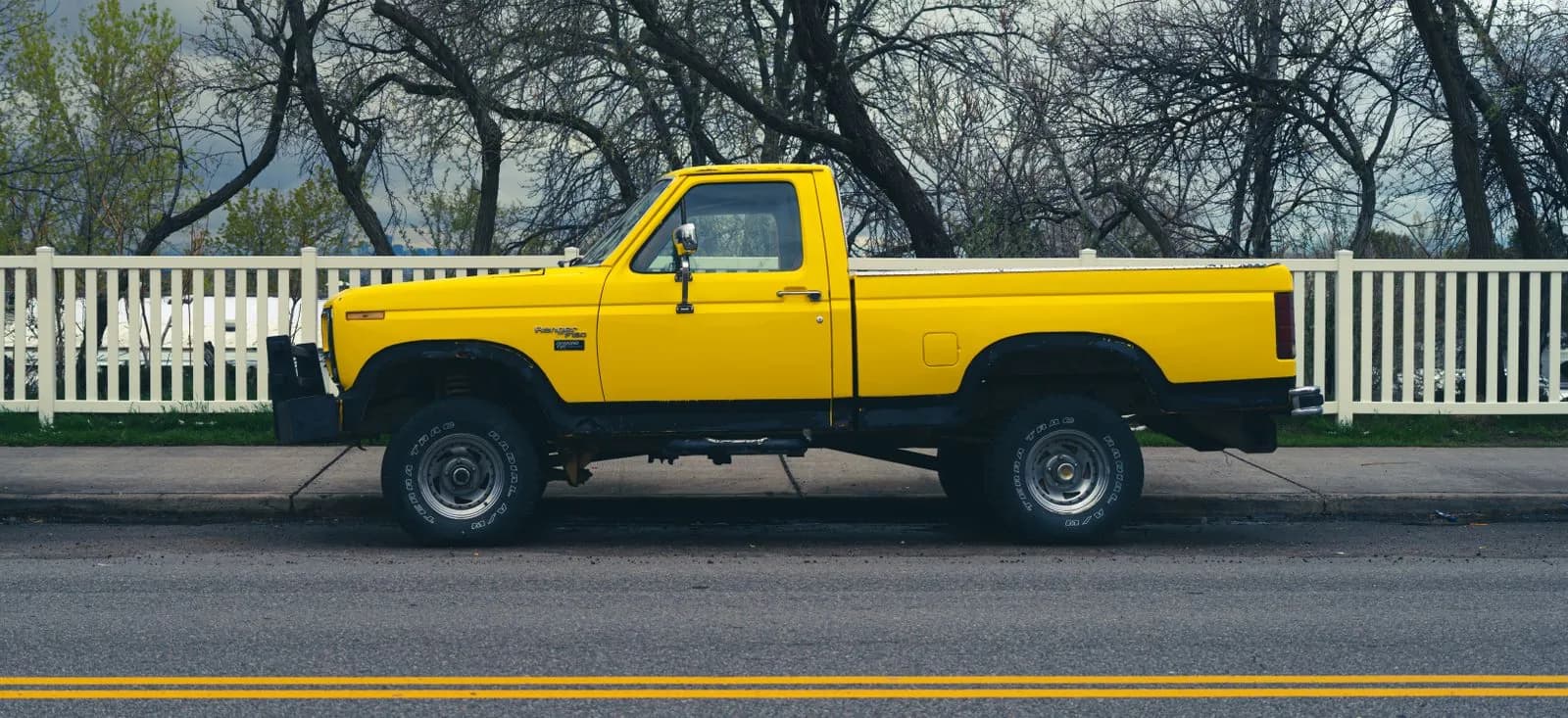 Yellow pickup truck parked roadside